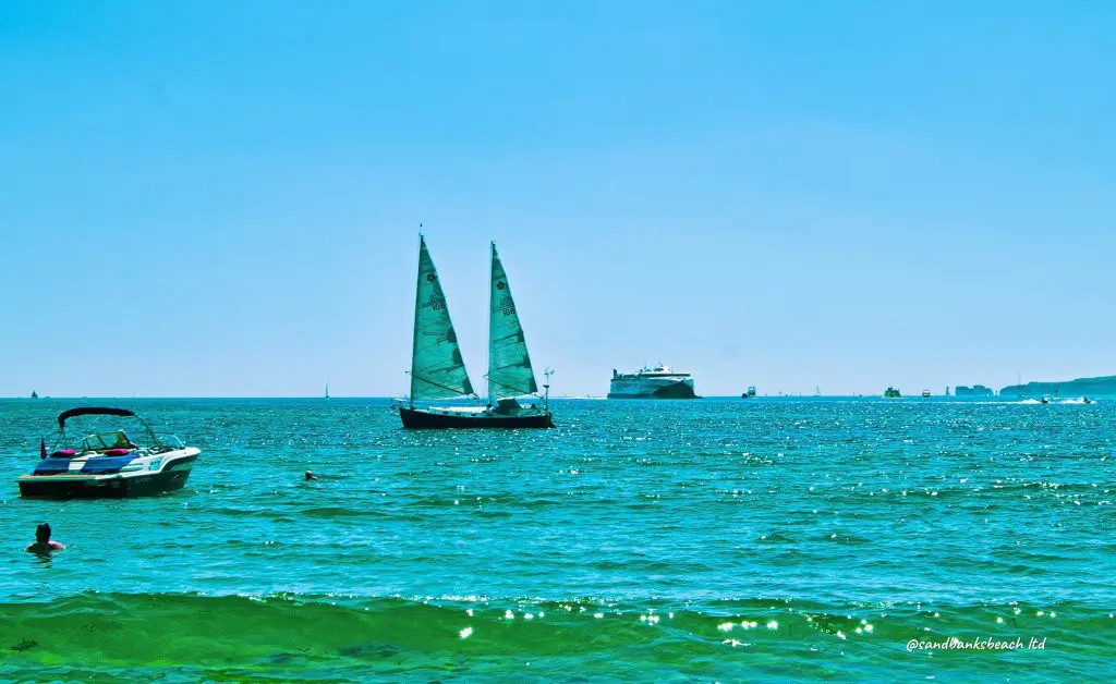 Three boats float serenely at Sandbanks Beach